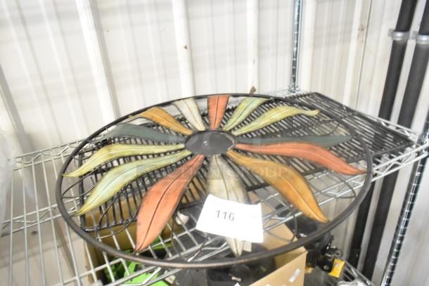 Colorful metal wall decoration with leaf pattern on wire rack. Auction label reads "116".