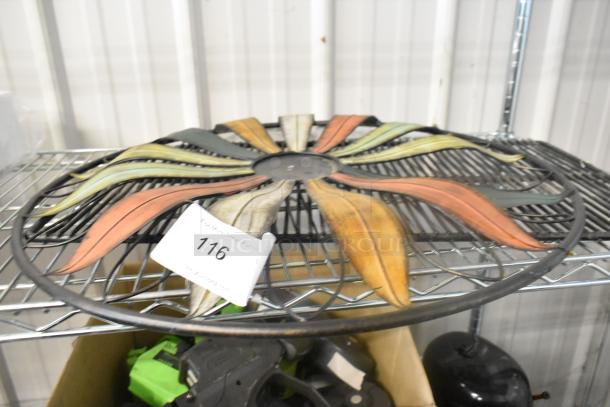 Decorative multi-colored metal wall art on a wire rack. Auction tag 116 visible. Good condition.