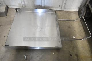 Stainless steel panel with corner brackets, slightly worn surface, no visible markings or dents. Appears solid and durable.
