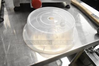 Clear poly dome cover, round, used condition, with ventilation hole on top; suitable for food storage.
