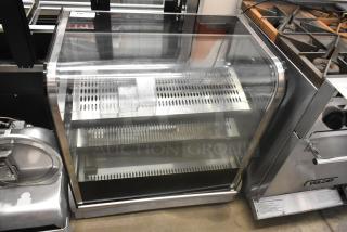 Stainless steel commercial countertop display case merchandiser, clear glass, two shelves, ventilation slots, excellent condition.