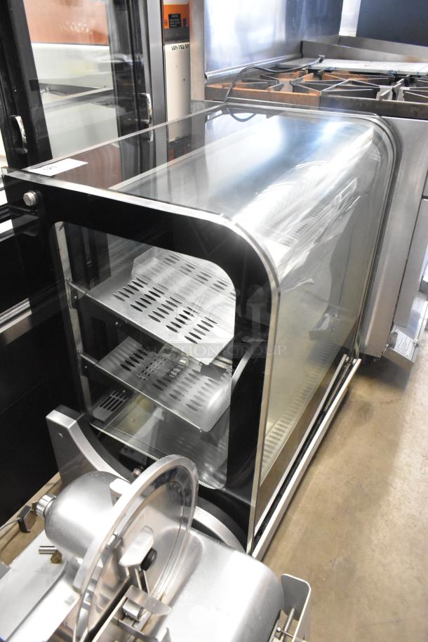 Stainless steel commercial countertop display case merchandiser with curved glass front, two perforated shelves, excellent condition.