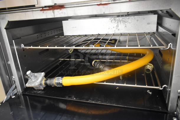 Interior of Vulcan 60SS-6B24GTN oven, showing a stainless steel rack and yellow gas hose connections.