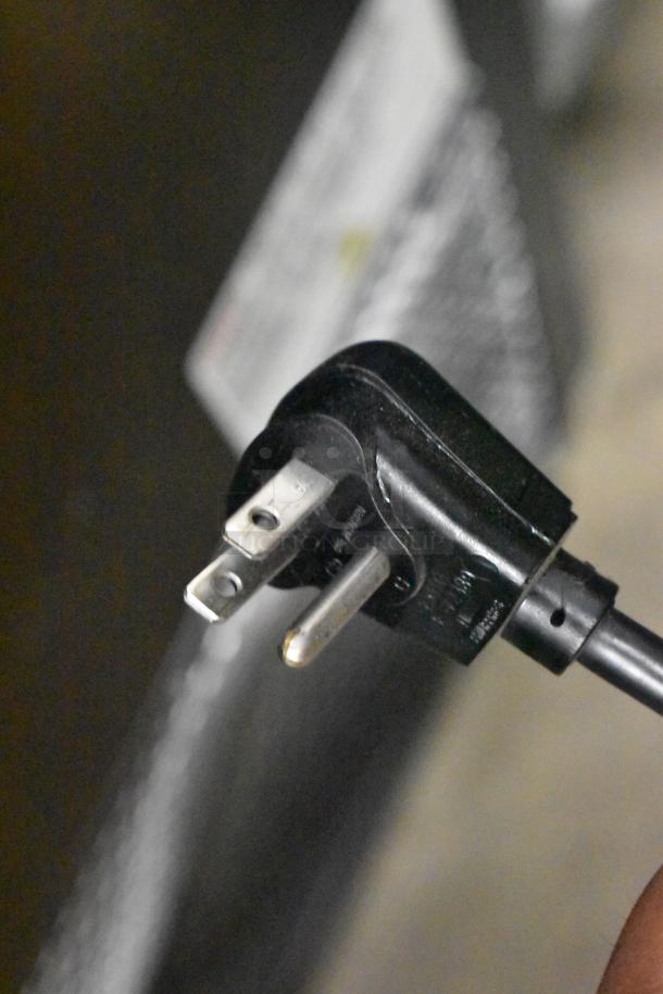 Close-up of a black electrical plug attached to the Scotsman HID312AB-1A ice machine. Plug shows standard prongs for 115V connection.