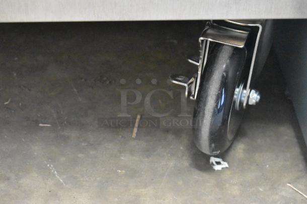 Caster wheel of a ServIt 423CH2UFNCF holding cabinet, new condition, on a concrete floor.