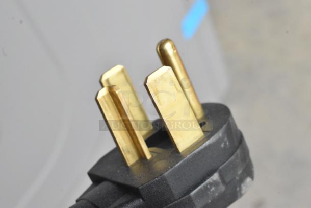 Close-up of a metal plug for the Crossover 2.0 DLHF0817EC2 front load dryer, showing three golden prongs.
