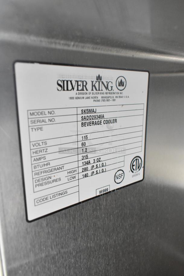 Silver King SK5MAJ stainless steel countertop milk dispenser, 115V, single phase. Label shows specs and model info.