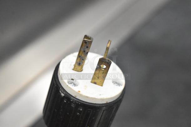 Close-up of a power plug for Electro Freeze 55TF-213 soft serve machine, showing metal prongs and black casing.