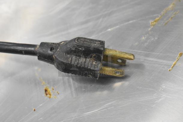 Close-up of a power plug for a Hamilton Beach 950 stainless steel countertop 3-head drink machine. Plug shows signs of wear.