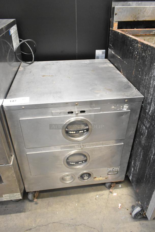 Toastmaster stainless steel commercial 2-drawer warming drawer, used, with visible wear and labels indicating settings.