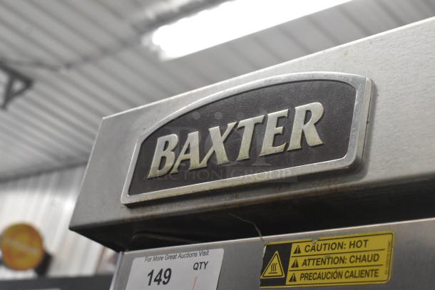 Baxter OV310G stainless steel commercial mini rotating rack oven on double pan rack with commercial casters, caution label visible.