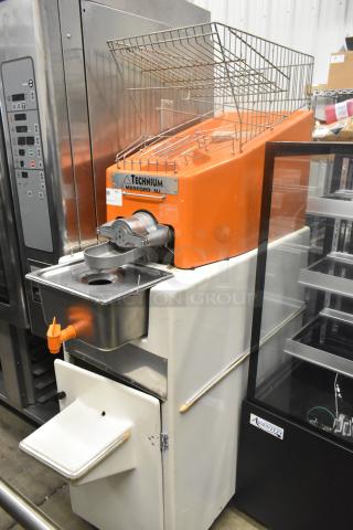 Metal commercial citrus juicer on casters, Technicum brand, orange color, 115 volts, 1 phase, with collection tray.