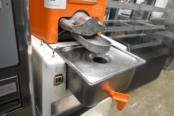 Metal commercial citrus juicer with spout and caster wheels. Operates on 115 volts, 1 phase. Features a stainless steel finish.