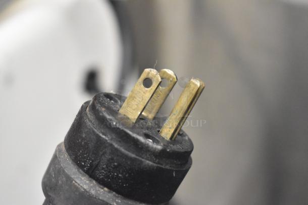 Close-up of a metal commercial citrus juicer's plug. Features durable casters, operates on 115 volts, 1 phase power.