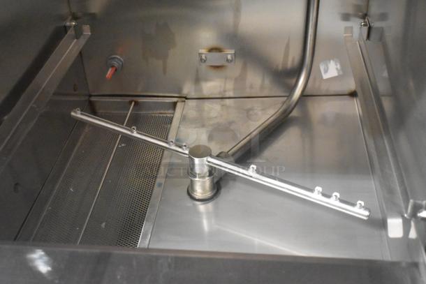 Hobart CUH-1 stainless steel undercounter dishwashing machine interior, new condition, showing spray arm and stainless finish.