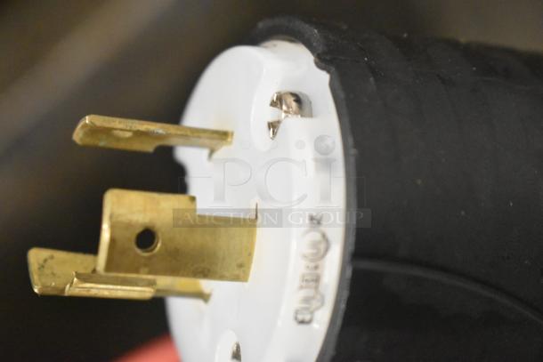 Close-up of a power plug for the Hobart Centerline CUH-1 dishwasher, showing brass prongs and part of the black casing.