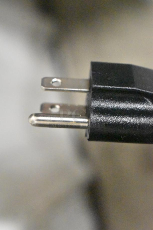 Close-up of a standard black electrical plug, part of the ServIt 423PDW12D1S display warmer.