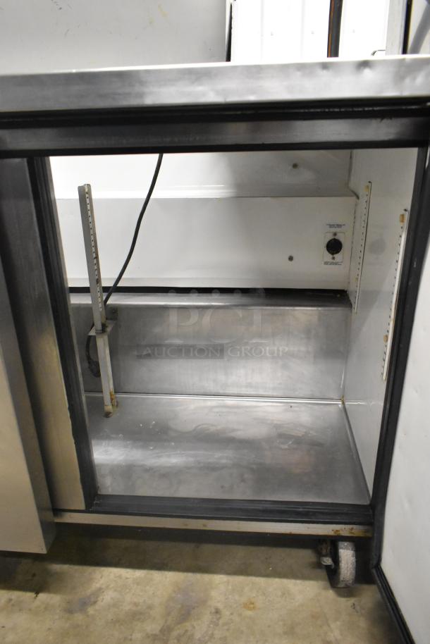 True TSSU-72-16 stainless steel sandwich salad prep table, showing interior shelving and commercial casters.