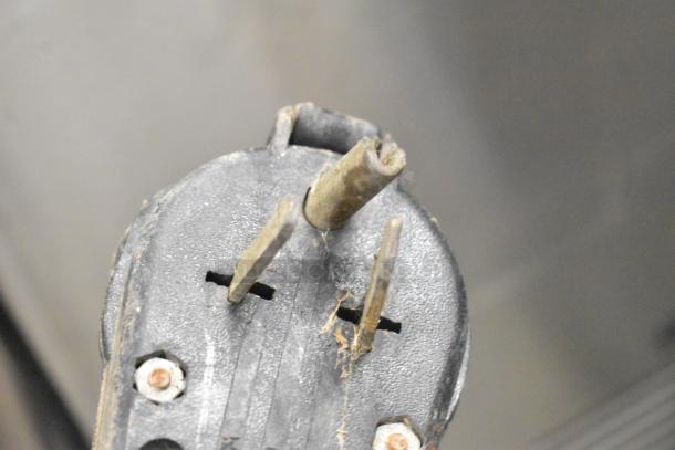 Close-up of a power plug with bent prongs for a Taylor 754-27 Soft Serve Ice Cream Machine. Some wear visible.