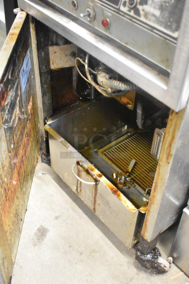 Henny Penny 600 stainless steel pressure fryer, commercial casters, 80,000 BTU, visible wear and residue, label inside door.