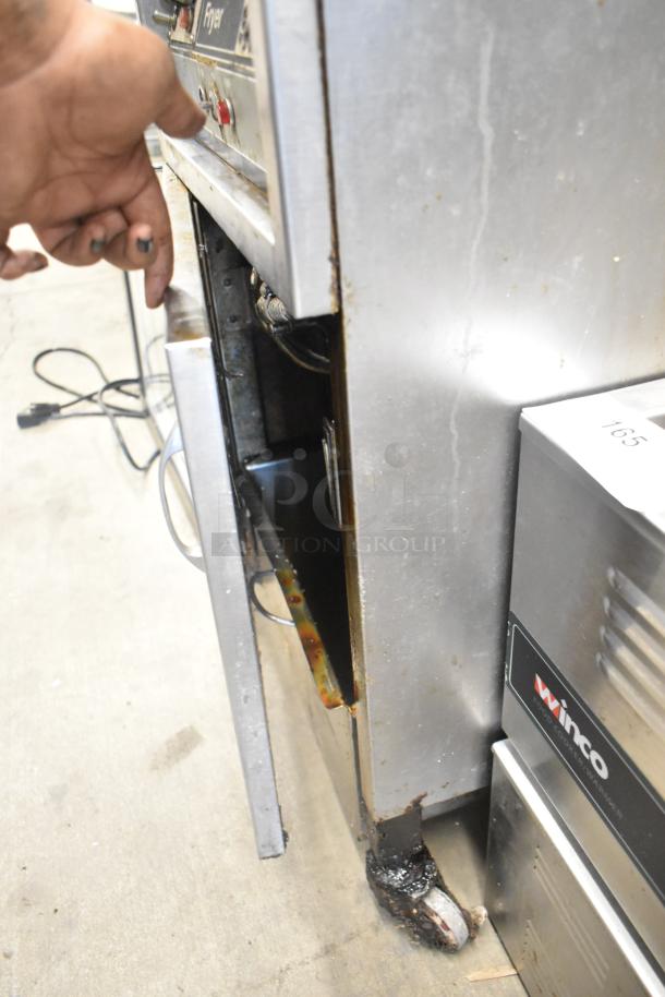 Henny Penny 600 stainless steel floor-style pressure fryer, 80,000 BTU, on commercial casters. Visible wear and grease stains.