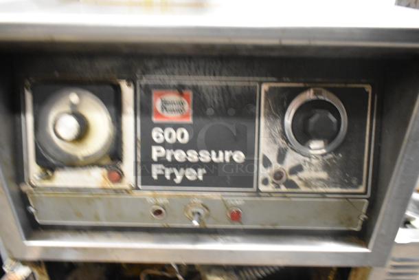 Henny Penny 600 pressure fryer, stainless steel, 80,000 BTU, commercial casters, visible wear, control panel shown.