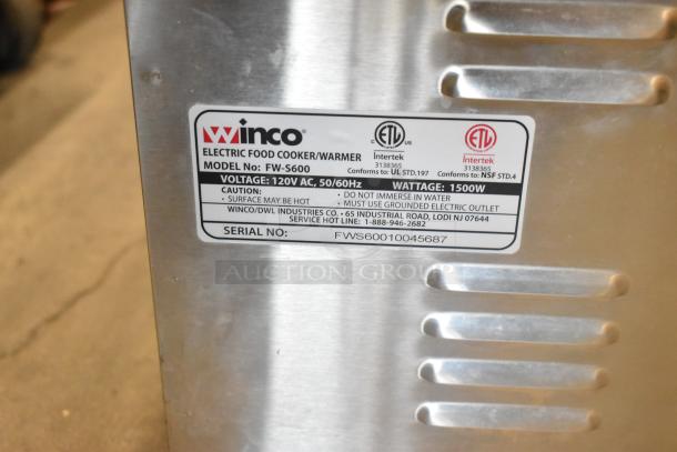 Two stainless steel food warmers, Winco FW-S600, Avantco, 115 volts, 1 phase. Label shows specs and safety instructions.