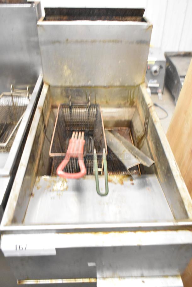 Imperial stainless steel commercial floor-style gas powered deep fat fryer with visible wear and fry baskets.