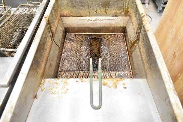 Imperial stainless steel floor-style gas deep fat fryer, used condition, showing oil residue and baskets, "oil level" marking visible.