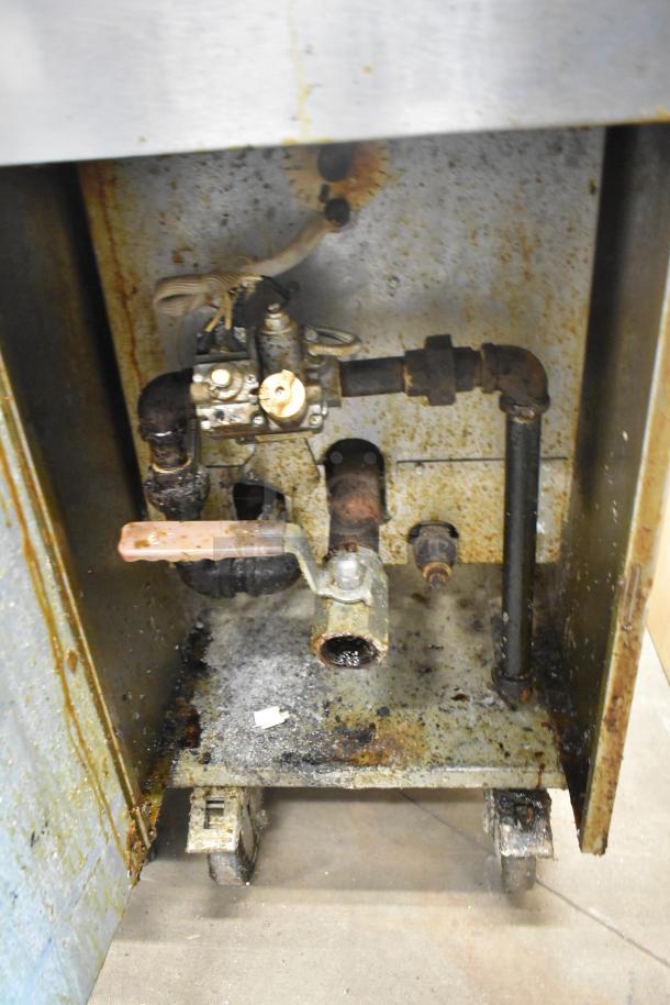 Imperial stainless steel commercial gas deep fryer, floor model. Visible wear and rust on interior components.
