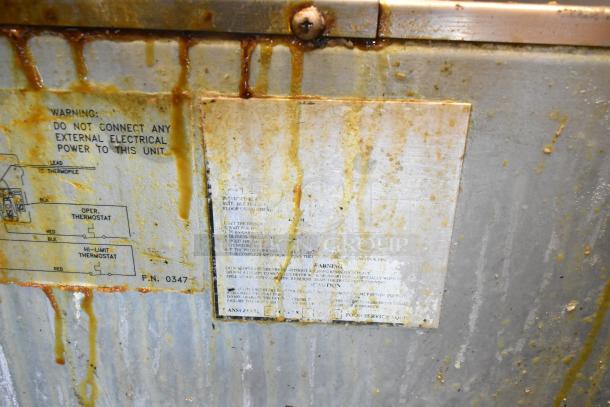 Imperial stainless steel gas deep fat fryer with visible wear and grease. Warning label advising no external electrical power connection.