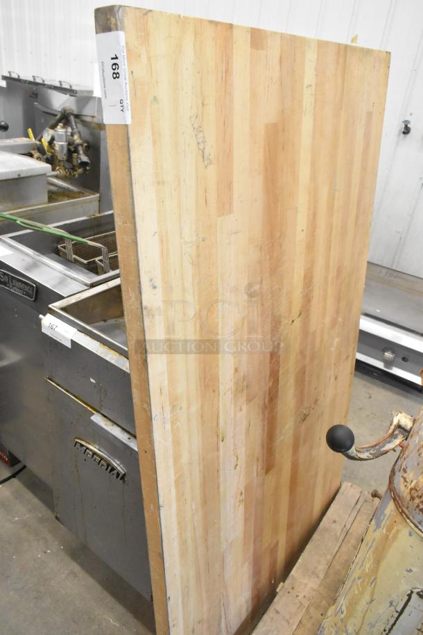 Wooden tabletop with a striped pattern, visible signs of wear, auction tag labeled "168" attached.