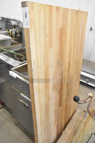 Wooden tabletop with a striped pattern, visible signs of wear, auction tag labeled "168" attached.