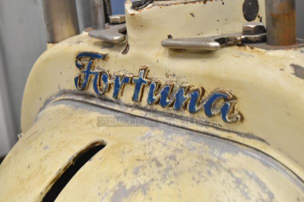 Fortuna metal commercial dough divider with vintage wear, featuring visibly worn blue logo on yellow body.