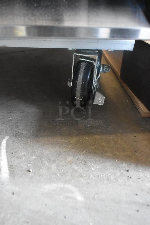 Brand new Avantco 178A23RHC stainless steel reach-in cooler wheel, showing commercial caster with foot pedal for locking.