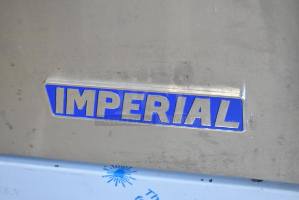 Imperial stainless steel commercial range, featuring 6 burners, flat top griddle, 2 ovens, over shelf, back splash.