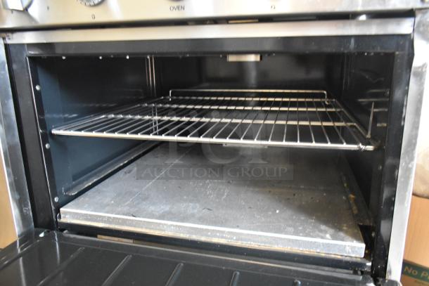Imperial stainless steel commercial electric range; 6 burners, right side griddle, 2 ovens, over shelf, backsplash.