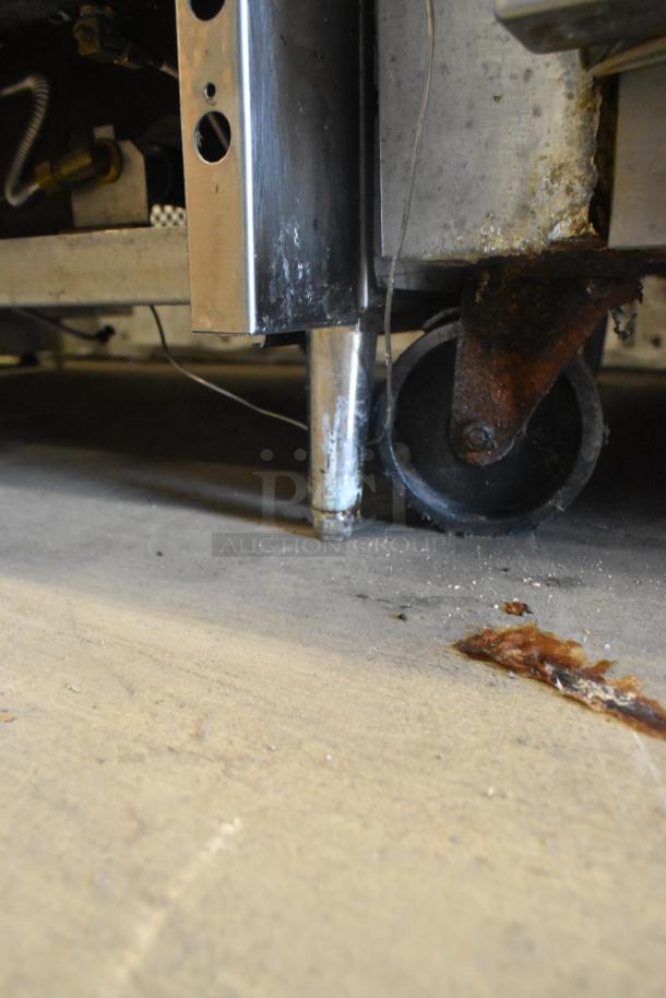 Continental 1FE commercial freezer's caster and base, showing signs of rust and wear, 115V, 1 Phase, stainless steel.