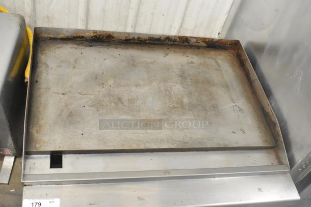 Stainless steel commercial countertop gas griddle, flat top design, used condition with visible wear and discoloration.