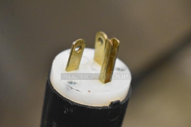 Close-up of a 2021 Aladdin Temp-Rite DH08 plug, showing gold prongs and white casing, part of stainless steel commercial tray return.