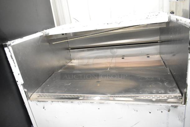 Stainless steel commercial horizontal grab-n-go merchandiser with open design. Visible wear, suitable for food display.
