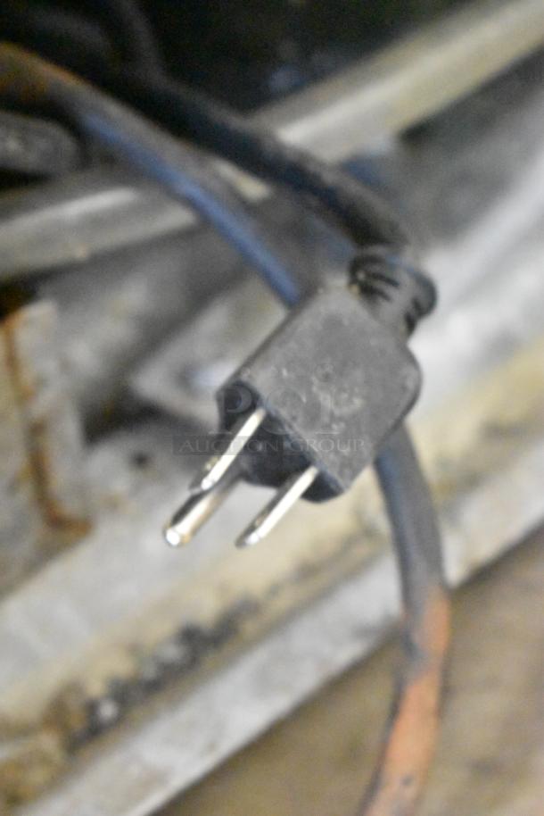 Close-up of a power plug, possibly from the Stainless Steel Commercial Horizontal Open Grab N Go Merchandiser.