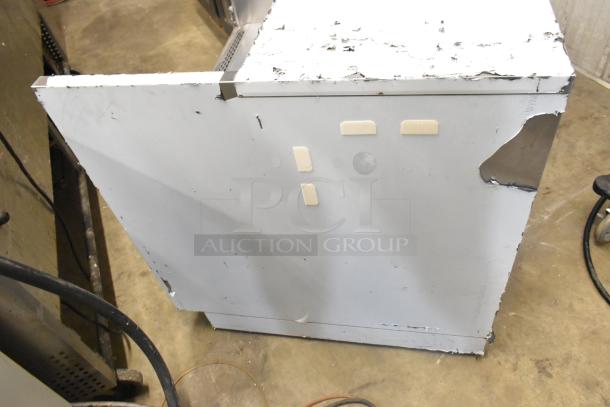 Stainless steel commercial grab-n-go merchandiser with visible wear and tear, including dents and scratches. Some protective padding attached on the surface.