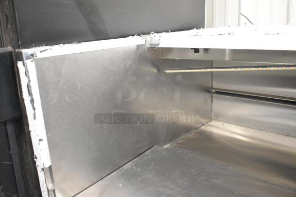 Stainless steel commercial horizontal open merchandiser, interior view, showing shelving. Suitable for grab-and-go displays.
