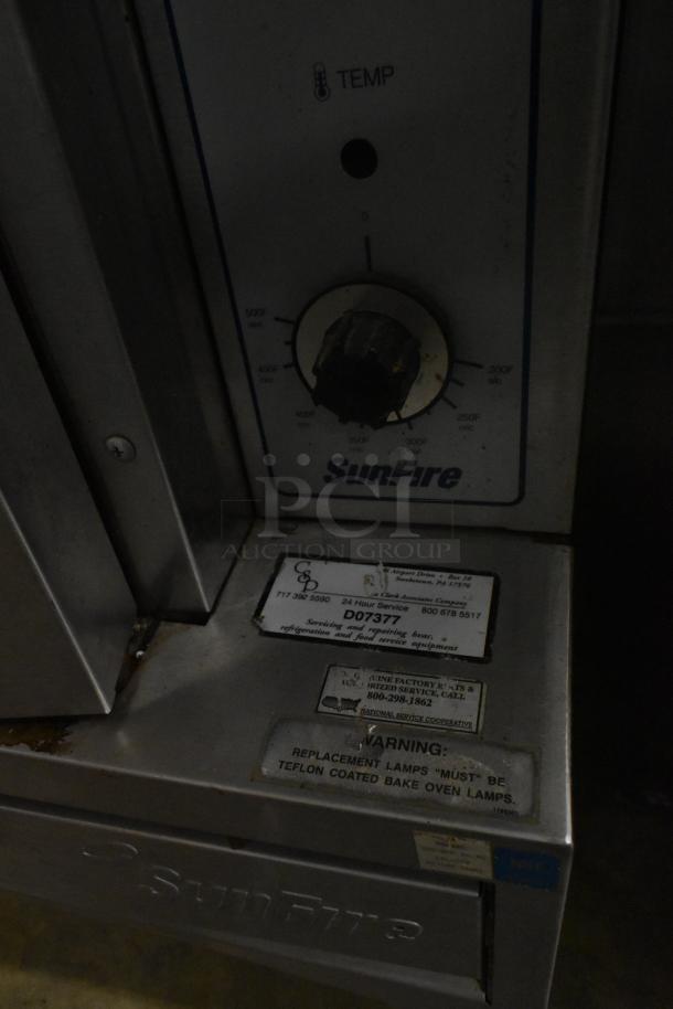 Garland SunFire stainless steel convection oven, view-through doors, metal racks, thermostatic controls. Labels on front panel.