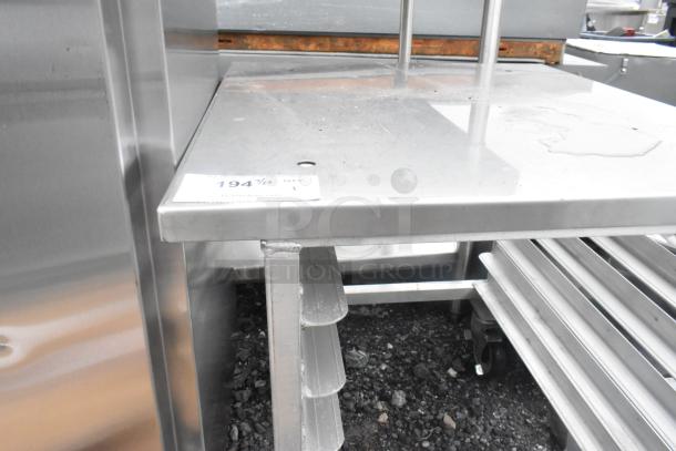 Brand new metal pan rack with commercial casters, slight scratches and dents visible, sturdy metal shelves, auction label attached.