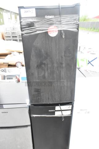 Galanz GLR33MBKE23 Mini Cooler, black, 115 volts, 1 phase. Includes two units. Plastic wrapping and power cords visible.