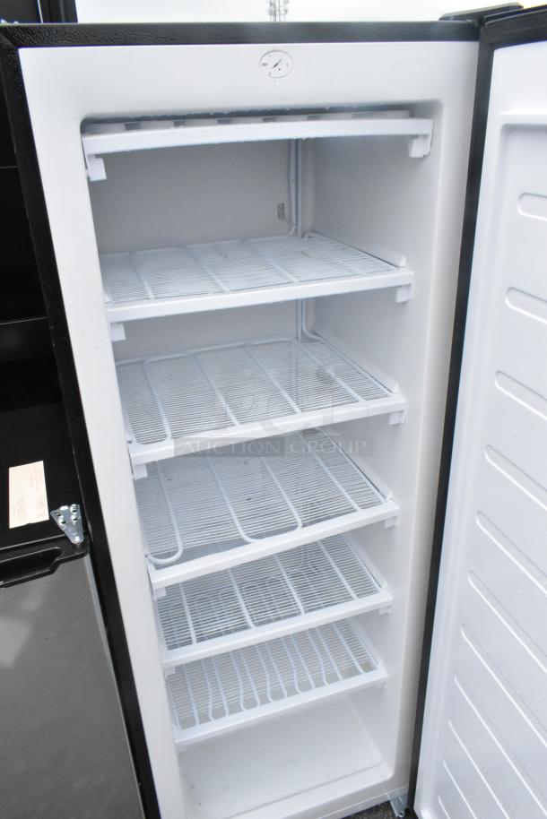 Frigidaire EFRF698-6COM single door reach-in freezer, 115 volts, pristine white interior with multiple wire shelves.