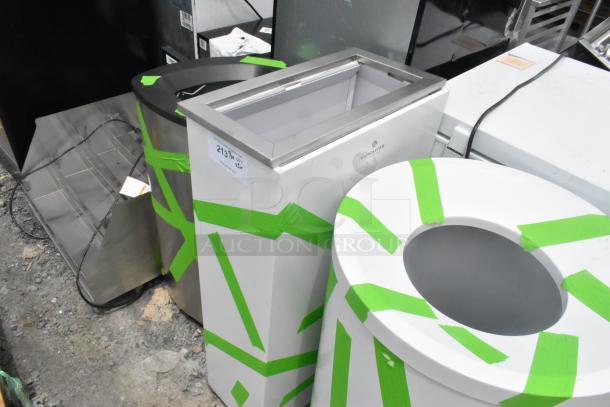 Three new Lancaster trash can shells with minor scratches and dents, wrapped in green tape. Model: 2137. Bid offers value multiplier.