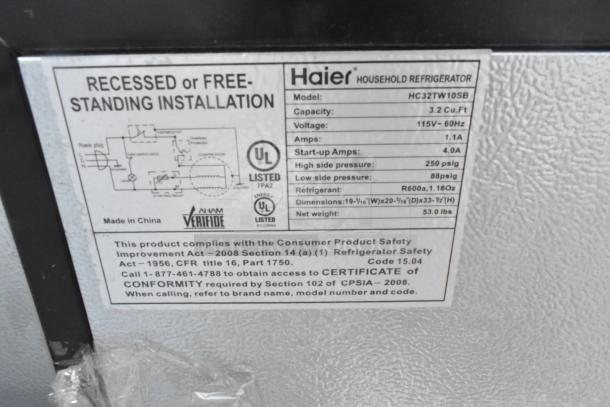 Label on Haier HC32TW10SB mini refrigerator, showing specs: 3.2 Cu.Ft capacity, 115V-60Hz, 1.1A, 53 lbs, R600a refrigerant.